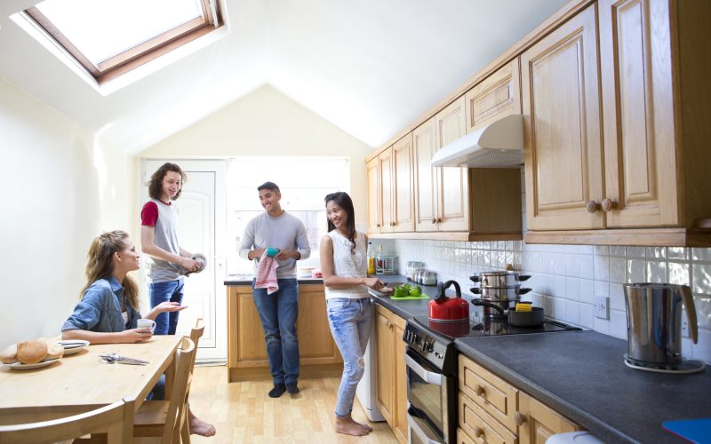 Four students gather and work in the kitchen
